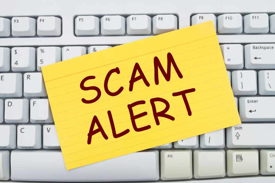 Computer keyboard keys with index card with words Scam Alert, Scam Alert