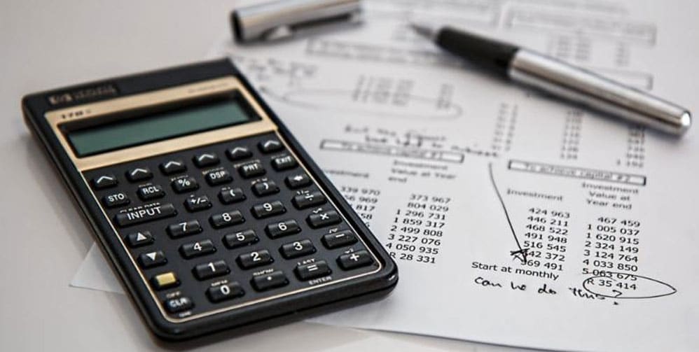 Calculator next to a sheet of paper with numbers