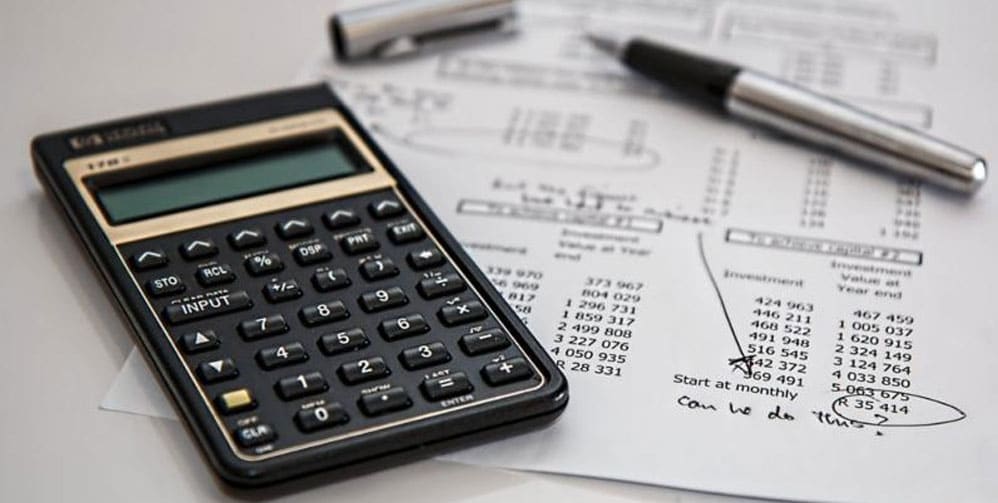 Calculator beside paper showing financial numbers