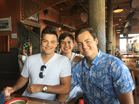 Three people sitting together at a restaurant table in a casual social setting.
