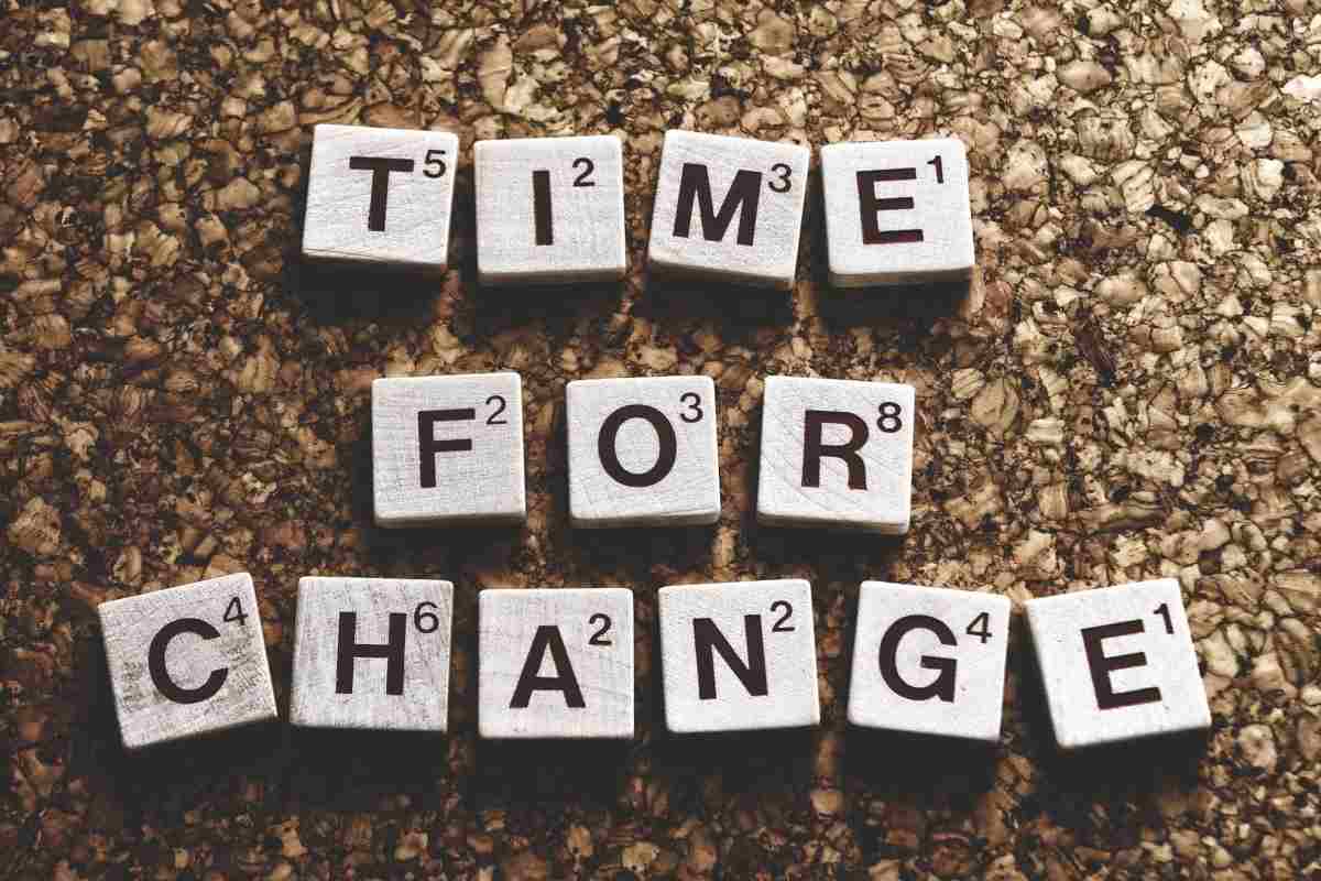 Scrabble tiles spelling “Time for Change” on a cork surface