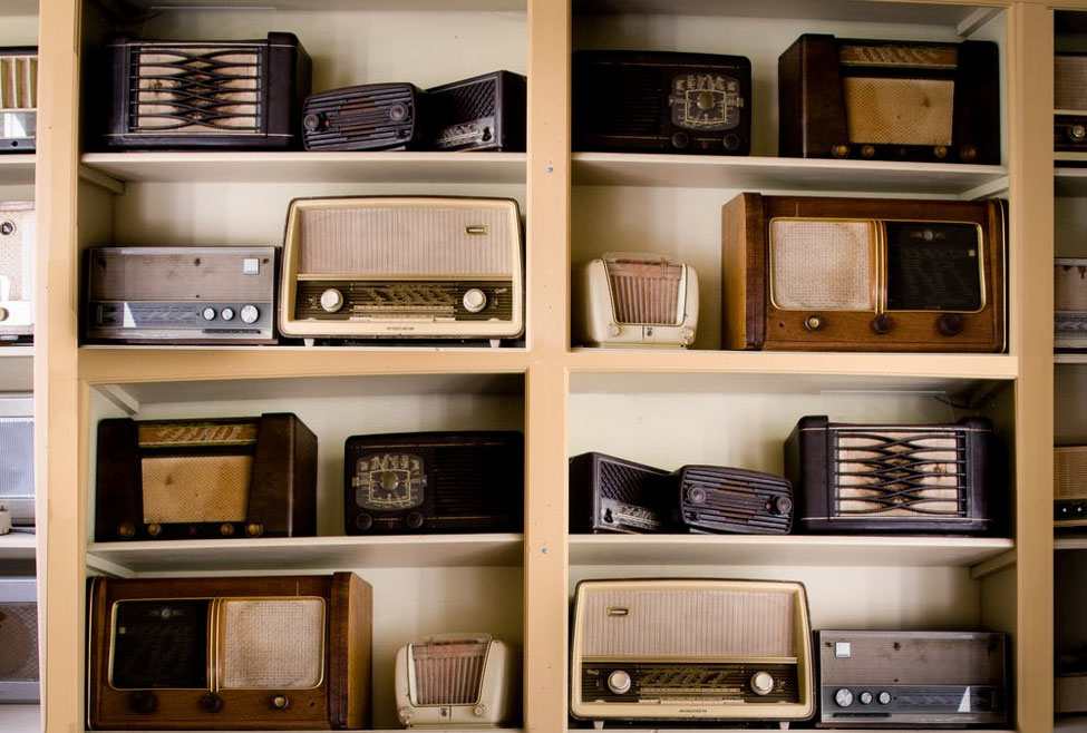 Collection of vintage radios displayed on shelves